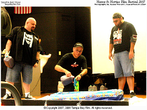 Horror & Hotties film festival organizer Andy Lalino loads fake blood into super soaker squirt guns. Notice the inflztable kiddie pool on stage so they don't mess it up with their antics. Once the kiddie pool lost its innocence, they should have sold it- guys, next year, try a pool in a solid, preferably dark, color. This one looked gay.